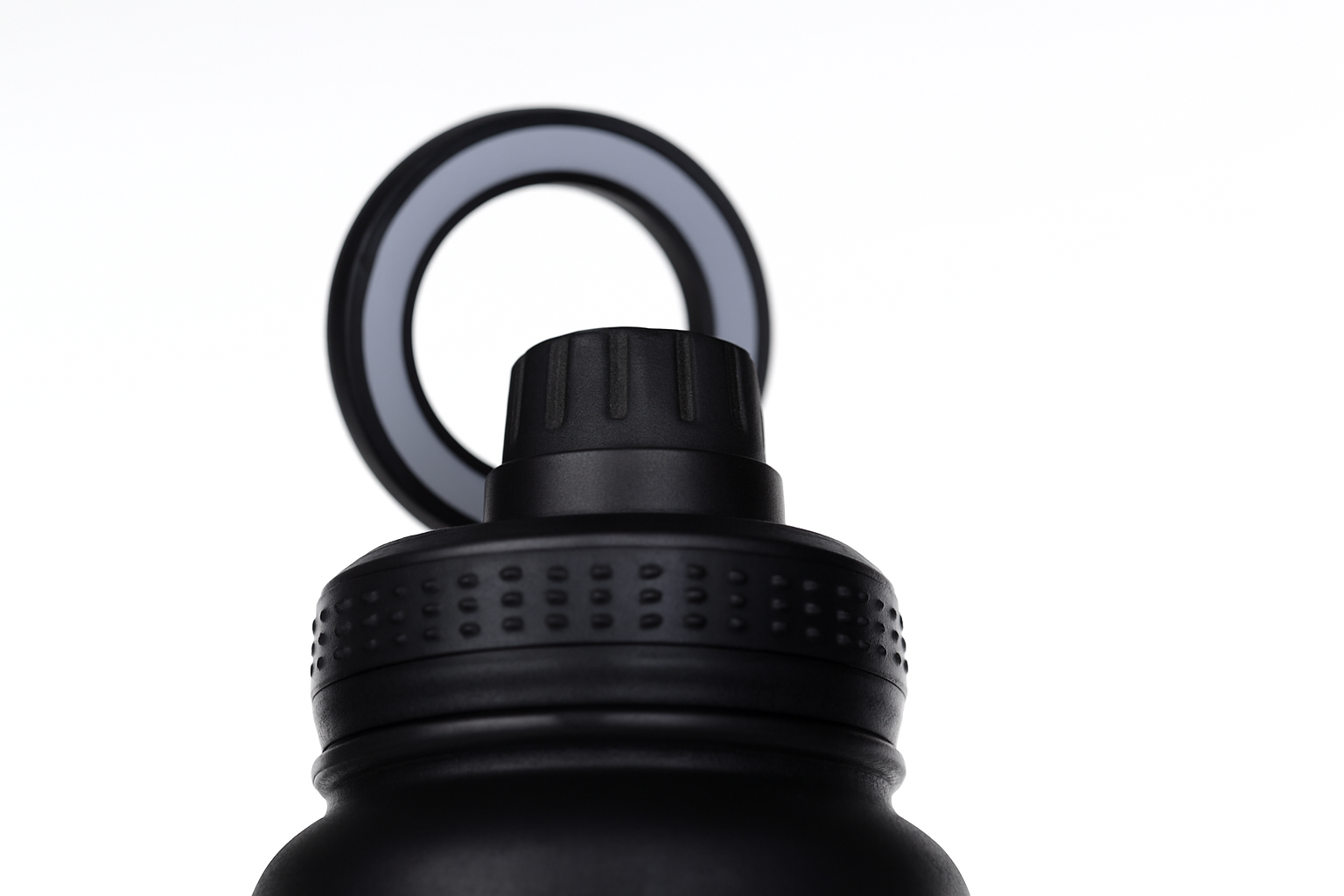 Close-up of a black water bottle cap with a carabiner on a white background